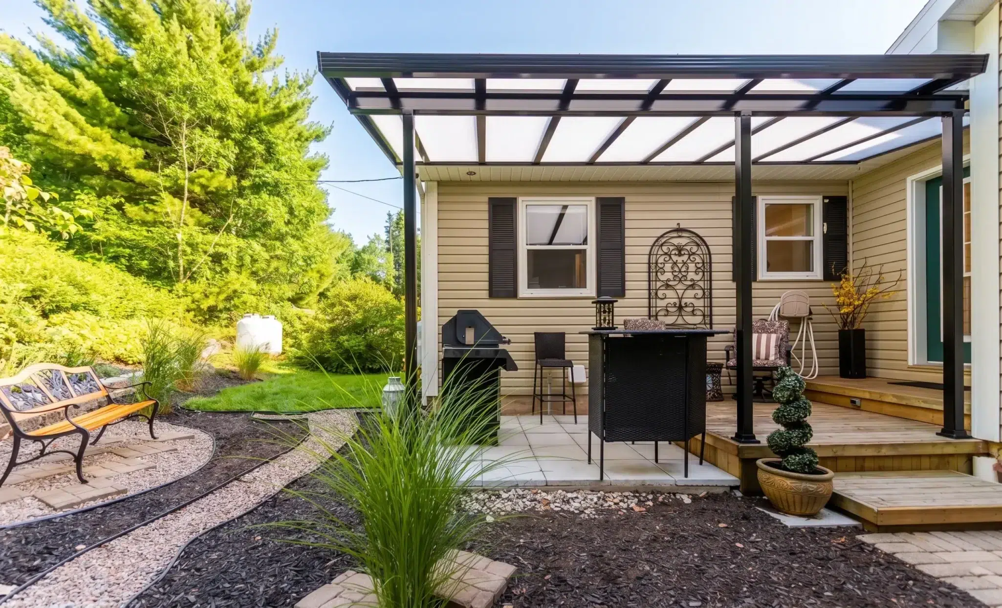 Backyard patio area featuring a black Sunspace acrylic patio cover over a deck.